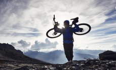 Biciclista de montanha transportando bicicleta, Valais, Suíça — Fotografia de Stock