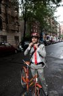 Jeune homme d'affaires ajustant casque de vélo dans la rue — Photo de stock