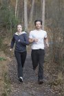 Couple running through forest — Stock Photo