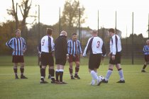 Referee and football players settling dispute — Stock Photo