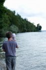 Father holding baby daughter by lake, Starnberg, Germany — Stock Photo