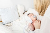 Mitte erwachsene Mutter legt Baby ins Kinderbett — Stockfoto