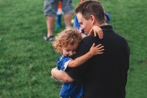 Ragazza che abbraccia suo padre in campo — Foto stock