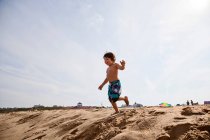 Хлопчик біжить на пляжі — стокове фото