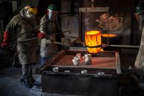Kapstadt, Südafrika, Arbeiter in Feuerwehranzügen bereiten Bronze vor dem Gießen vor — Stockfoto