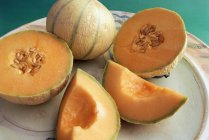 Melões cantaloupe cortados pela metade e cortados na bandeja — Fotografia de Stock