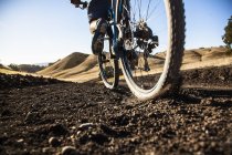 Vista superficiale ritagliata del giovane uomo in mountain bike su pista sterrata, Mount Diablo, Bay Area, California, USA — Foto stock