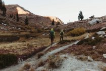 Visão traseira de dois caminhantes do sexo masculino caminhando até a paisagem acidentada, Mineral King, Sequoia National Park, Califórnia, EUA — Fotografia de Stock