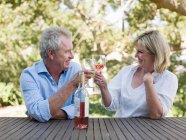 Couple toasting avec vin en plein air — Photo de stock