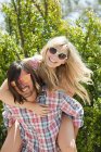 Young man giving young woman piggyback — Stock Photo