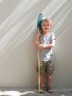 Boy standing by wall with fishing net, portrait — Stock Photo