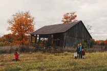 Famille moyenne adulte avec trois filles se promenant dans un champ rural — Photo de stock