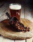 Bodegón de pasas en cucharada con vaso de cerveza - foto de stock