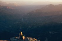 Женщина, сидящая на краю скалы Моро, Национальный парк Секвойя, Калифорния, США — стоковое фото