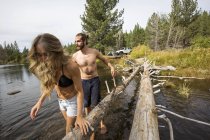 Young couple crossing river, Lake Tahoe, Nevada, USA — Stock Photo
