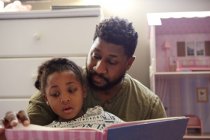 Père lisant à sa fille — Photo de stock