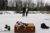 Mala vermelha, botas, xale, patinação de casal no fundo, Whitby, Ontário, Canadá — Fotografia de Stock