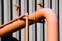 Vista ravvicinata di tubi industriali arancioni luminosi impianto esterno — Foto stock