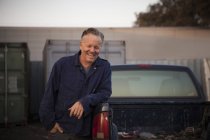 Mann lehnt an Lastwagen und lächelt — Stockfoto
