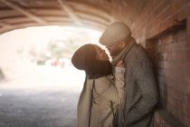 Romantic happy couple enjoying city during winter holidays in park tunnel — Stock Photo