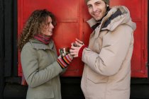 Paar in Winterkleidung mit warmen Getränken — Stockfoto