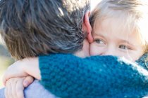 Close-up sobre vista ombro de menina abraçando pai — Fotografia de Stock