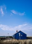Visão traseira do homem pintura casa azul — Fotografia de Stock