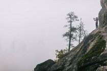Jovem de pé na montanha, fotografando vista, perto de Shaver Lake, Califórnia, EUA — Fotografia de Stock