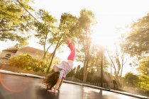 Giovane ragazza che fa stand su grande trampolino, vista basso angolo — Foto stock