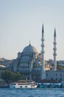 Boat on golden horn and yeni mosque — Stock Photo