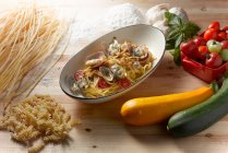 Pasta mit Gemüse und Kräutern auf einem hölzernen Hintergrund — Stockfoto