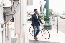 Young man pushing bicycle on rail station platform — Stock Photo