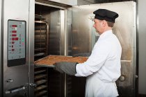 Männlicher Koch backt Plätzchen in gewerblicher Küche — Stockfoto