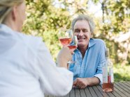 Paar stößt mit Wein im Freien an — Stockfoto
