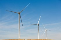 Tre turbine eoliche affiancate da cielo blu nuvoloso — Foto stock