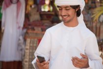 Мужчина с Ближнего Востока смотрит на мобильный телефон — стоковое фото