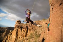 Female rock climber swinging out on rope, Smith Rock State Park, Oregon, USA — Stock Photo