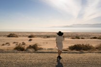 Rear view of woman wearing sunhat looking away at desert, Salton Sea, California, USA — Stock Photo