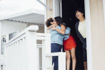 Grandmother and granddaughter hugging on porch — Stock Photo
