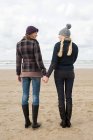 Жінки тримаються за руки біля моря — стокове фото