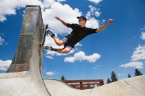 Jeune homme planche à roulettes sur la rampe du parc à patins, Mammoth Lakes, Californie, É.-U. — Photo de stock