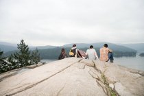 People on rock by a lake — Stock Photo
