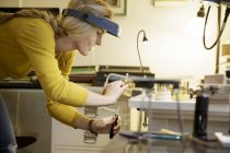 Female jewellery maker using clamp in design studio — Stock Photo