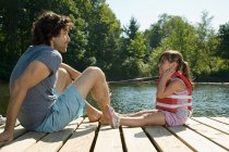 Отец и дочь на пристани в озере — стоковое фото