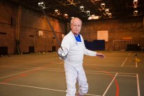 Senior man in fencing suit holding foil — Stock Photo