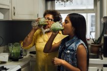 Grandmother and granddaughter drinking smoothies — Stock Photo