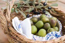 Green Olives in straw basket — Stock Photo