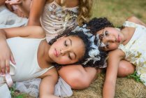 Група молодих дівчат, одягнена як феї, лежить на траві — стокове фото