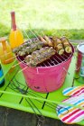 Barbecue with meat and vegetables on sticks outdoors — Stock Photo