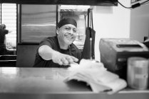 Шеф-кухар на комерційній кухні посміхається на камеру — стокове фото